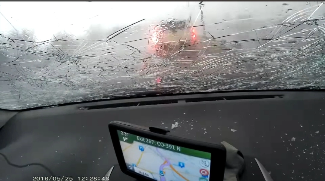 Driver’s view through a severely spider-cracked windshield that spread from ignored damage